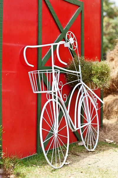 Винтажный белый велосипед возле красной стены — стоковое фото