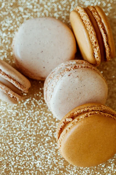 Baunilha de luxo e macaroons de caramelo no fundo de ouro — Fotografia de Stock