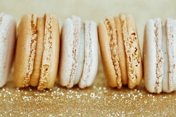 Baunilha de luxo e macaroons de caramelo no fundo de ouro — Fotografia de Stock