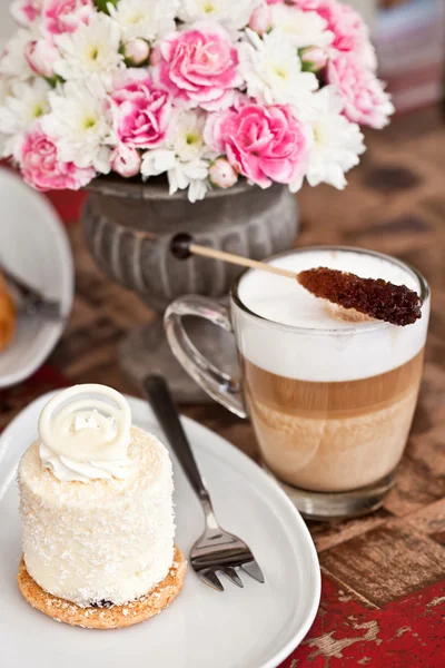 Pastel de coco con flores, latte y croissant de chocolate —  Fotos de Stock