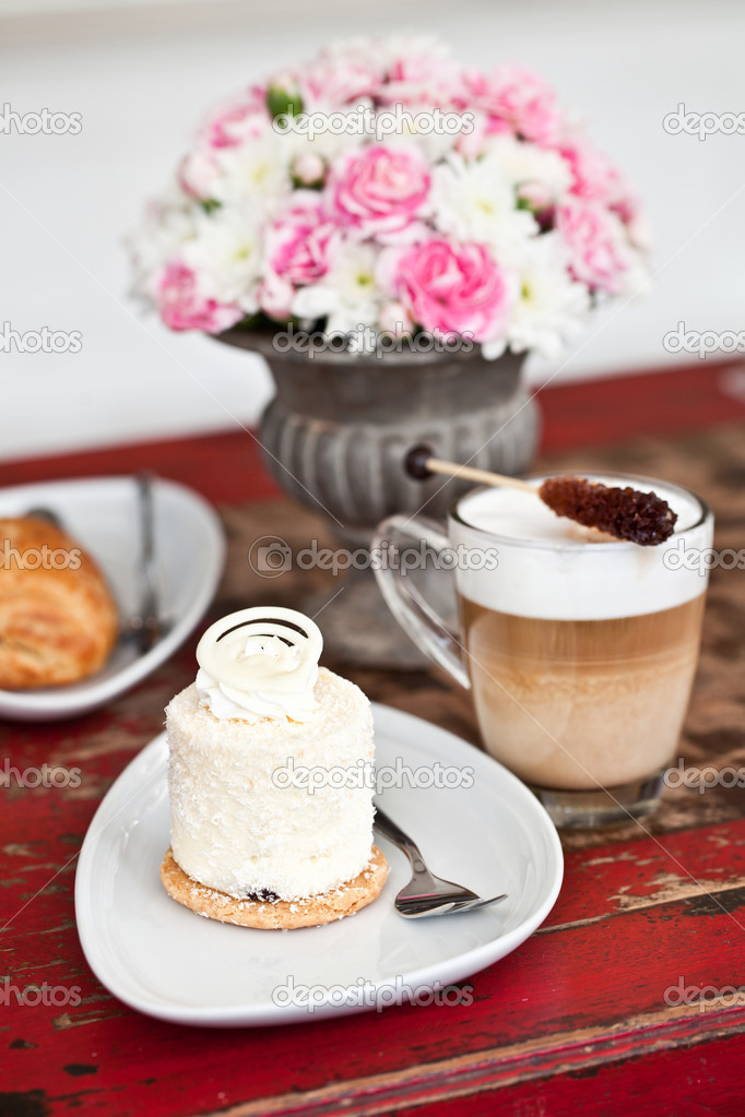 Coconut pastry with flowers, latte and chocolate croissant Stock Photo ...