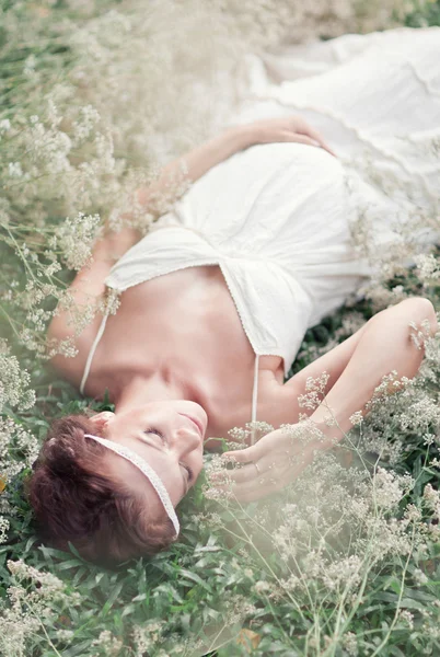 Mujer embarazada joven con flores gypsophila — Foto de Stock