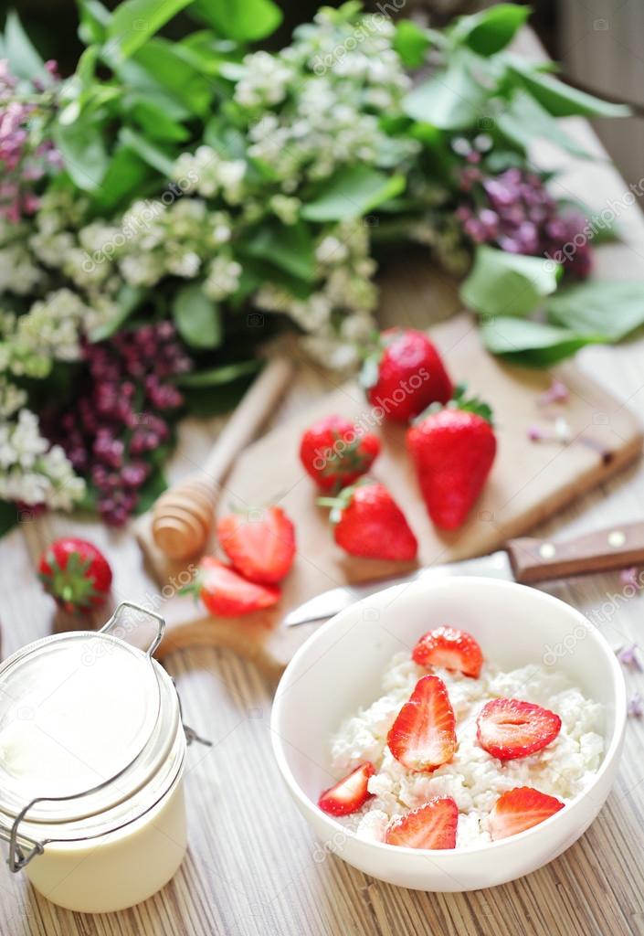 Healthy breakfast with strawberry, cottage cheese, honey and cream.