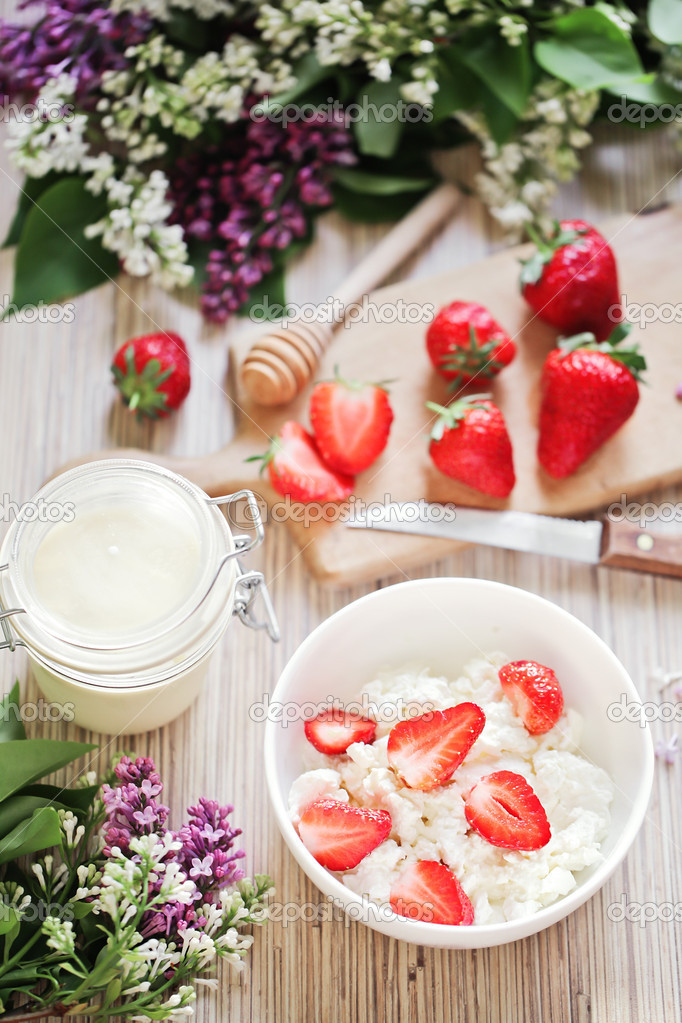 Healthy breakfast with strawberry, cottage cheese, honey and cream.