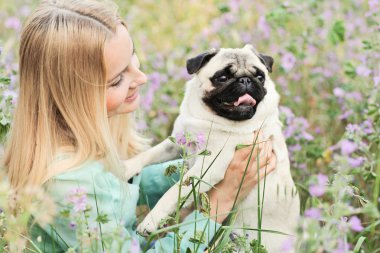 sevimli sarışın kız köpeğini parka eğleniyor