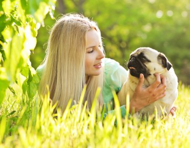 sevimli sarışın kız köpeğini parka eğleniyor