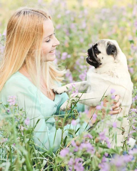 Cute blond girl having fun with her dog at the park — Stock Photo, Image