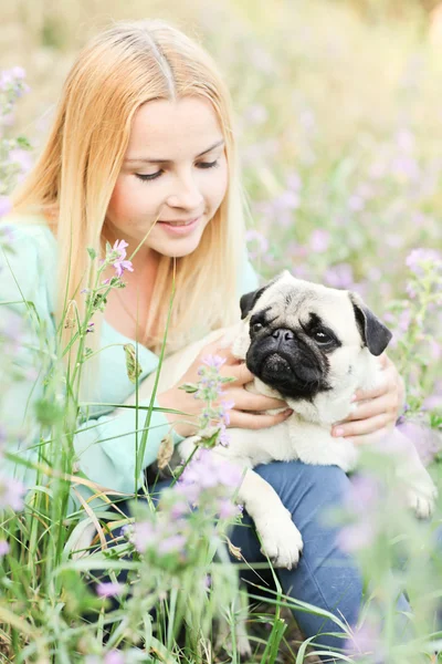 Roztomilá blondýnka se baví s pejskem v parku — Stock fotografie