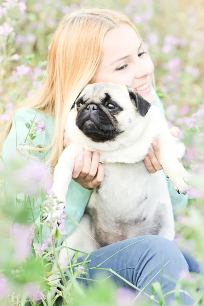 Roztomilá blondýnka se baví s pejskem v parku — Stock fotografie