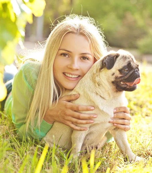 Schattig blond meisje met plezier met haar hond in het park — Stockfoto