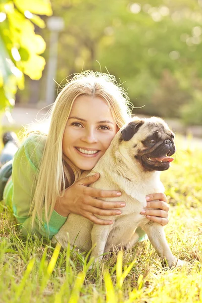 Sevimli sarışın kız köpeğini parka eğleniyor — Stok fotoğraf