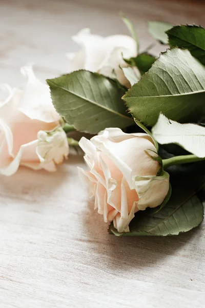 Τρία λευκά τριαντάφυλλα στο τραπέζι ξύλινο — Φωτογραφία Αρχείου
