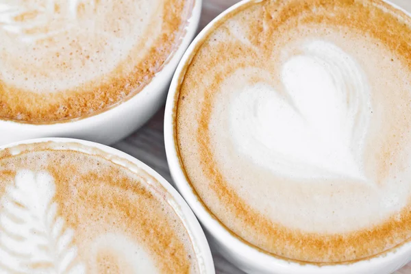 Drei weiße Tassen Kaffee sortiert auf dem Tisch — Stockfoto