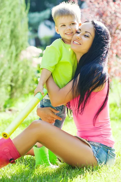 Mladá matka a její malý syn venku v barevné holínky — Stock fotografie