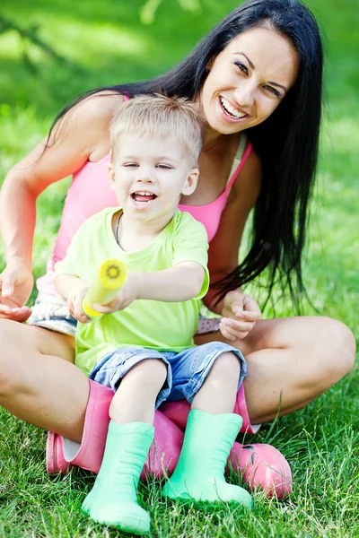 年轻的母亲和她的小儿子在户外在彩色橡胶靴 — 图库照片