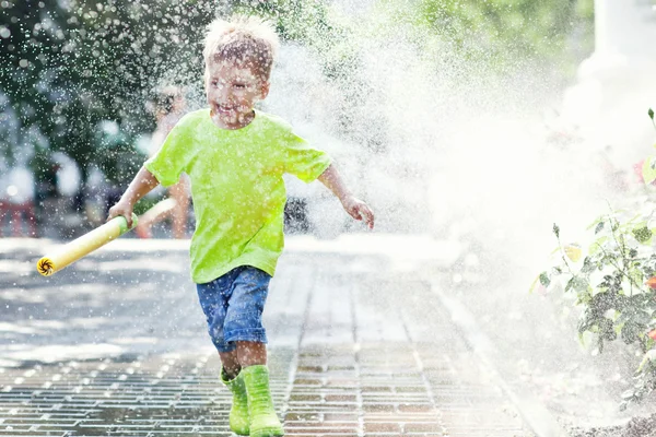 Dítě a matka nosí růžové a zelené déšť boty — Stock fotografie