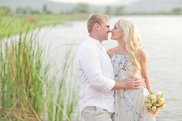 Hermosa pareja feliz sentado en el campo de lavanda púrpura, divertirse en glade floral, naturaleza de verano, concepto de amor —  Fotos de Stock