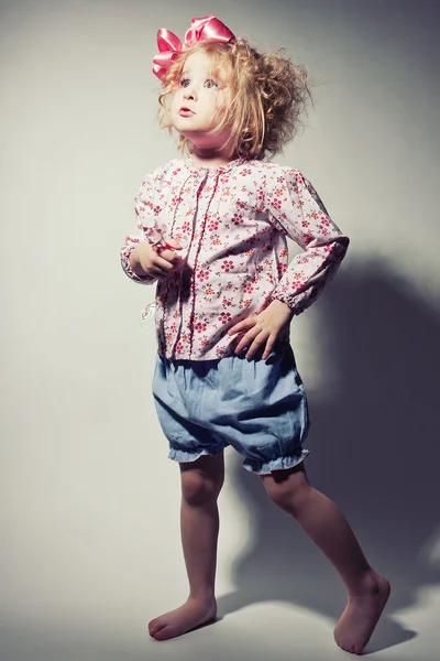 Beautiful young blond female child with curly hair posing in studio — Stock Photo, Image