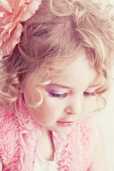 Beautiful young blond female child with curly hair posing in studio — Stock Photo, Image