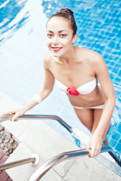 아름 다운 갈색 머리 여자는 수영장에서 등반 — 스톡 사진