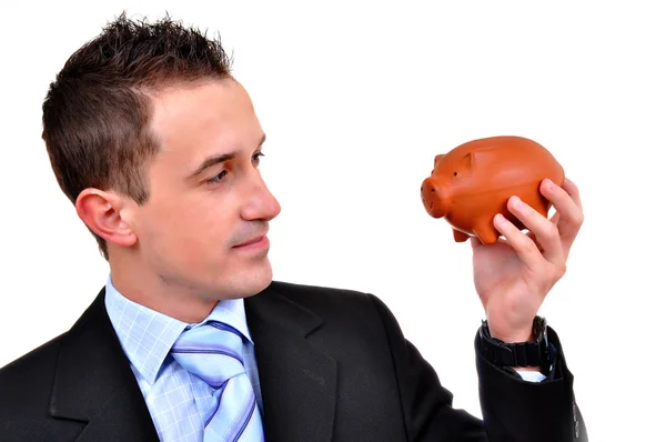 Um empresário atraente a segurar o Piggy Bank. Tudo sobre fundo branco — Fotografia de Stock