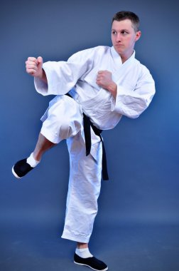 gri zemin üzerine özel egzersiz yaparak genç spor karate man