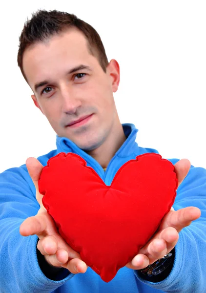 Young man holding heart in his hand. He is giving it somebody. Isolated on white. — Stock Photo, Image