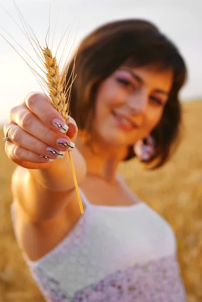 Young beautiful girl showing a corn with her hand — Stock Photo, Image