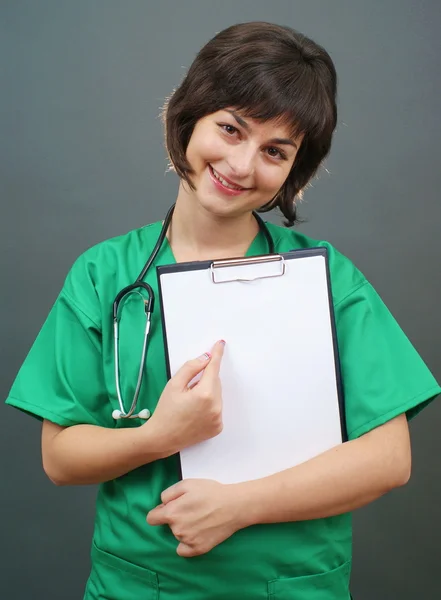 Médico senhora atraente em fundo cinza — Fotografia de Stock