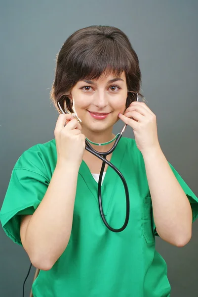 Médico senhora atraente em um fundo sobre cinza — Fotografia de Stock