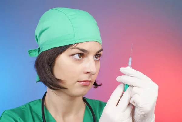 Ung sjuksköterska i mask med spruta — Stockfoto