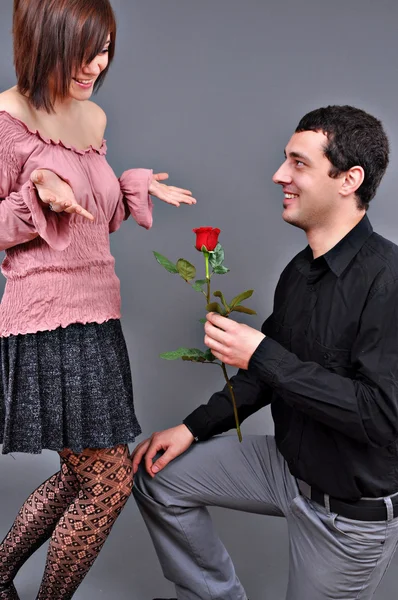 Felice bella coppia adolescente, un ragazzo che dà una rosa alla sua ragazza Fotografia Stock
