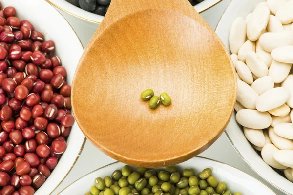 Variety beans in bowls and wooden soup spoon — Stock Photo, Image