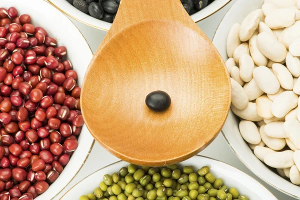 Variety beans in bowls and wooden soup spoon — Stock Photo, Image