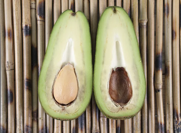 Avocado cut on floors on two half on a table — Stock Photo, Image