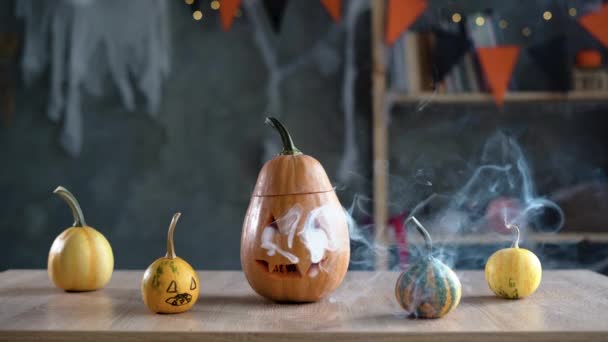 Zucca di Halloween pazza spettrale su un tavolo scuro con fumo. Decorazioni per la vacanza autunnale. Jack spaventoso. — Video Stock