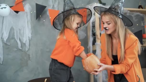 Lycklig familj, mor och barn, lycklig flicka får frön från pumpa och förbereder sig för Halloween.Happy Halloween. — Stockvideo