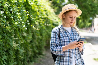Bir Avrupa şehrinde akıllı telefon kullanan genç beyaz bir kadın. Hippi kız interneti cep telefonuyla geziyor, kısa mesajlar gönderiyor ve dışarıda iletişim kuruyor. Seyahat ve teknoloji konsepti