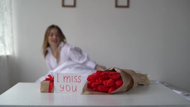 Jó reggelt lányok! Ajándék és üdvözlőlap azzal a felirattal, hogy hiányzol. Meglepetés a szeretett nődnek a születésnapján. Vörös tulipán — Stock videók