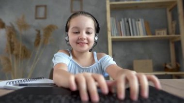Web kameralı kulaklıklı kız bilgisayarlı klavyede hızlı bir şekilde mesaj yazmayı öğreniyor. Liseli bir kız müzik dersi dinliyor.