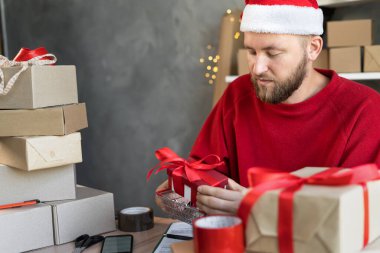 Noel Baba şapkalı bir işadamının portresi evde ya da depoda Noel için hediye kutularıyla çalışıyor. Adamın biri alışveriş sepetine kırmızı bir kutu koyar. Yeni yıl için satış ve teslimat.