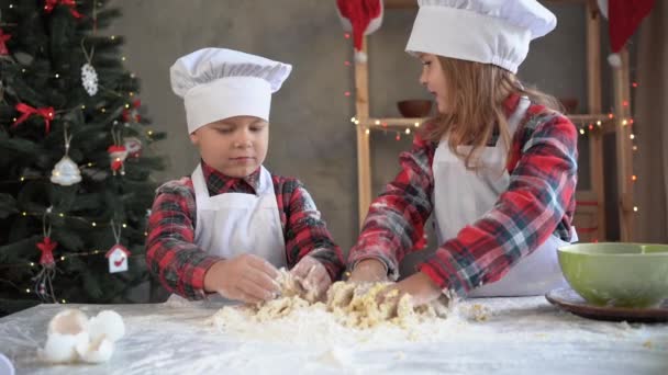 Barn förbereder sig för att baka kakor i köket till jul. Broder och syster bagare knåda deg för pepparkakor eller paj. Begreppsbarn baka — Stockvideo