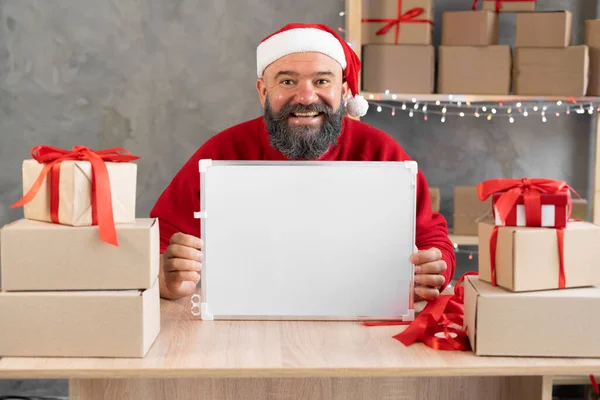 起業家のサンタは収益シェアと顧客マーケティング セールスダッシュボードを増やします クリスマス倉庫と郵便物の買い物 家のオフィスに箱を持った男 小規模事業主コンセプト — ストック写真