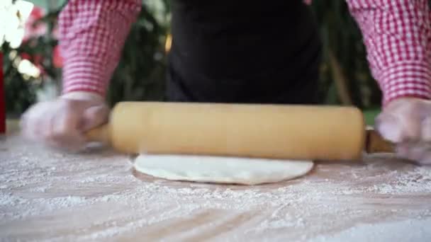Femme chef prépare la pâte à pizza en déroulant avec les mains et rouleau à pâtisserie sur fond de table farinée. Boulanger avec de la pâte dans une pizzeria mains gros plan — Video