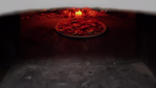 Pizza italiana in un forno tradizionale a legna. Cuocere la pizza vegana con funghi in pizzeria. — Video Stock