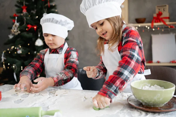 Kinder backen in der heimischen Küche Weihnachtsplätzchen. Familienweihnacht. Bruder und Schwester beim Lebkuchenbacken. — Stockfoto