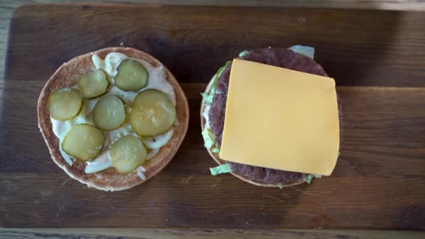 Manos femeninas haciendo hamburguesa fresca, vista superior. Comida rápida — Vídeos de Stock