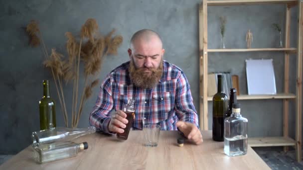 Een bebaarde alcoholist die thuis whisky drinkt. Alcoholverslaving. Behandeling van alcoholisme. — Stockvideo