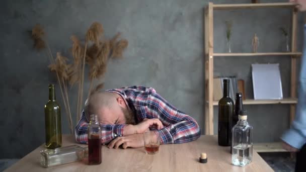 Alcolizzato che dorme a casa a tavola. Dipendenza da alcol, ubriaco di depressione. — Video Stock