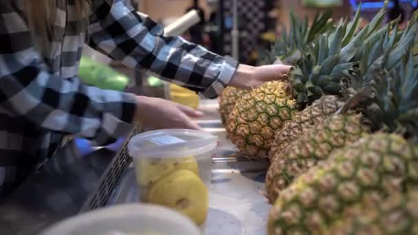 Försäljning och shopping i dagligvaruhandeln koncept. Kvinna plockar tropisk ananas på disken, hand närbild. Ekologiska livsmedel. — Stockvideo